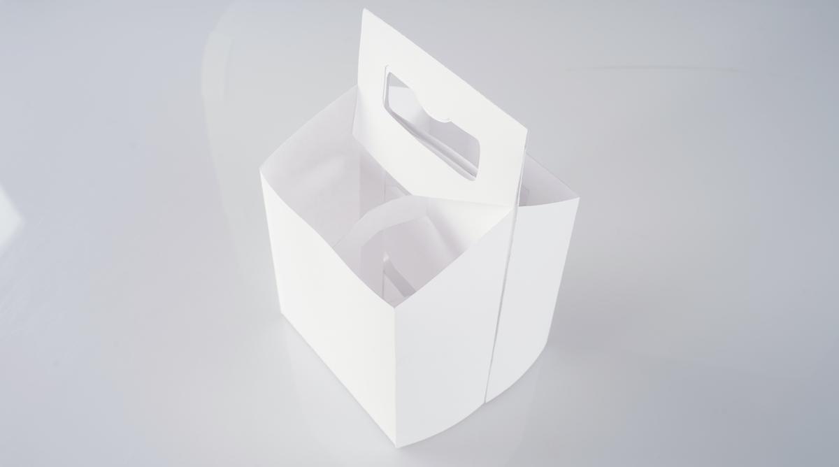 White prototype of the four-bottle carrier, seen from above at an angle