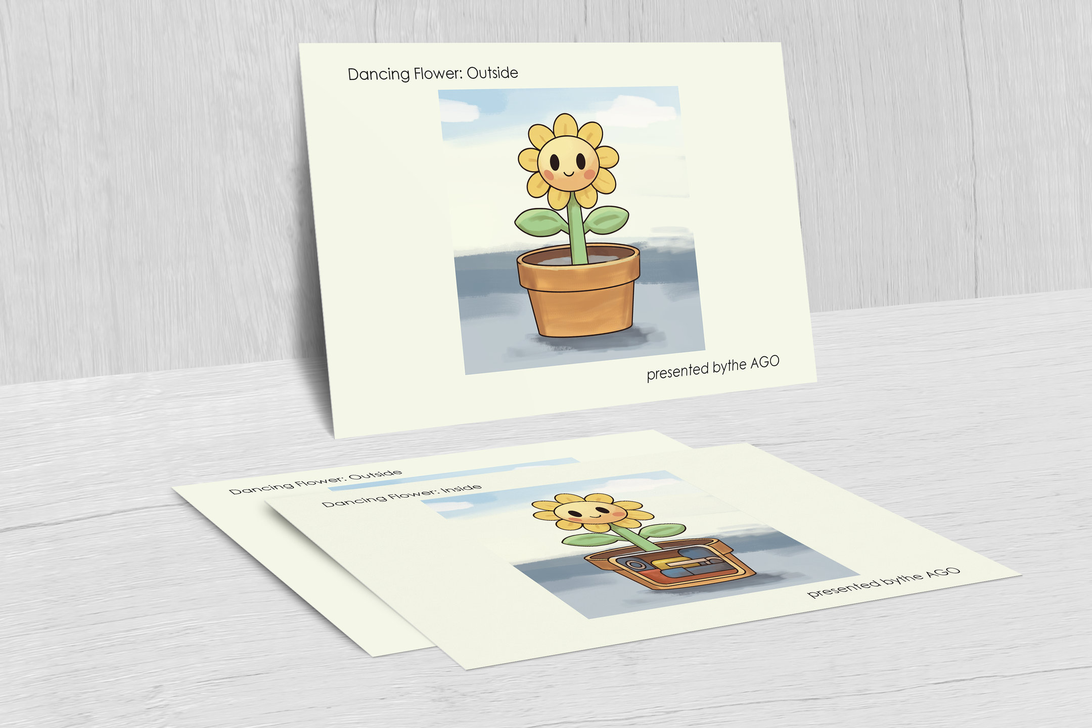 The dancing flower postcard standing against a wall, with two more cards lying flat in front of it