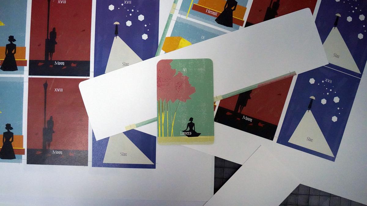 Test print sheet of the card designs with one trimmed card laid on top