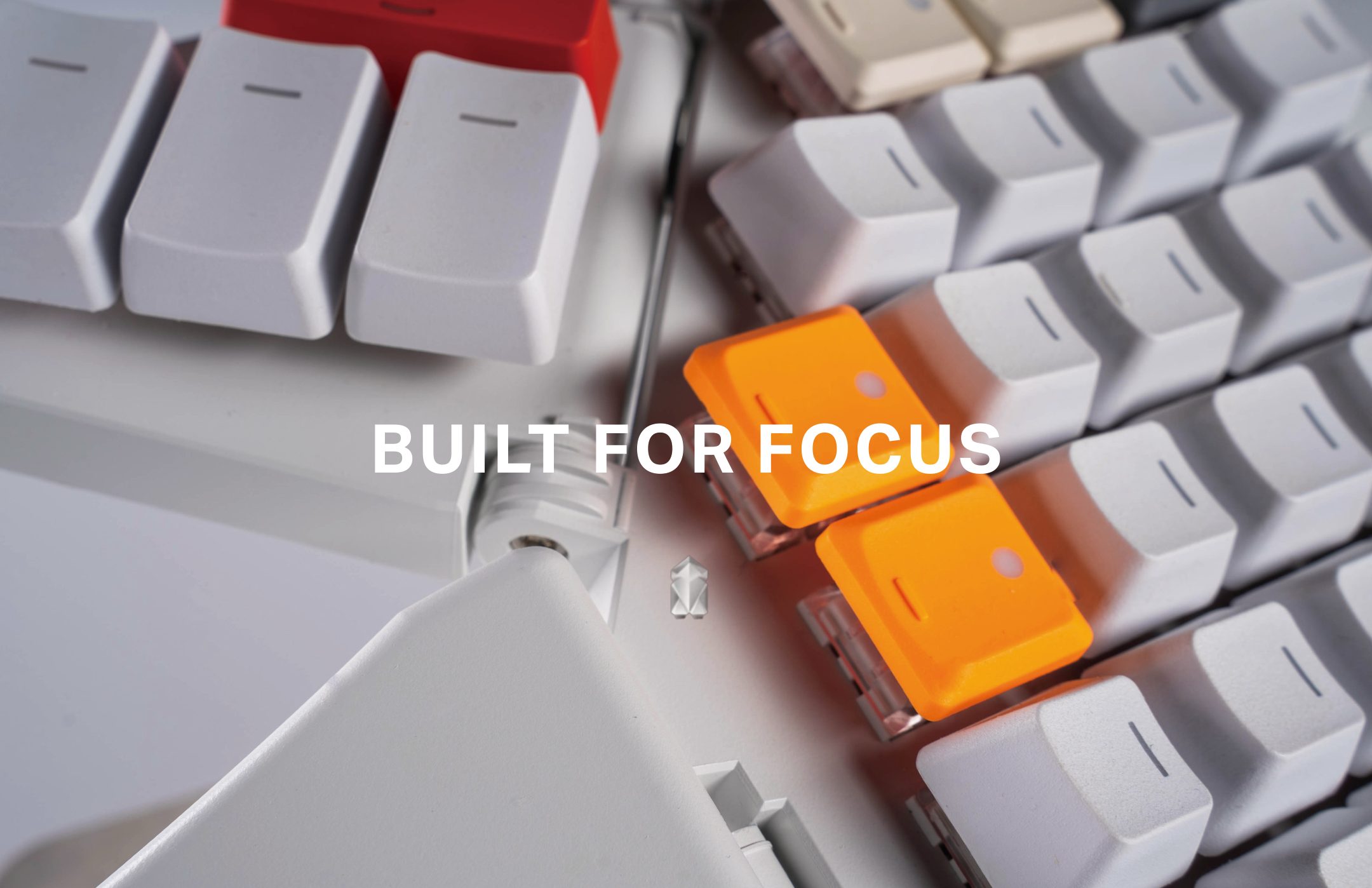 Close-up of orange keycaps on the Moonlander under the line Built for Focus