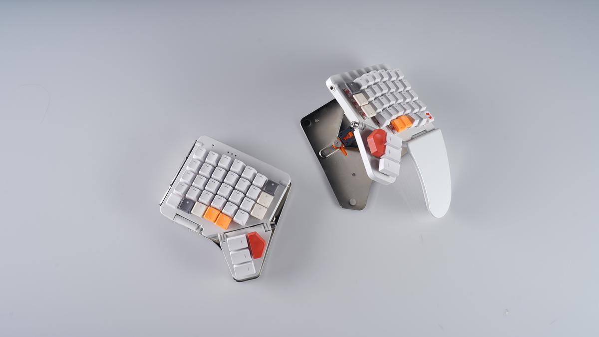 Unedited product photo with the halves offset and an orange keycap in the middle